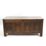 A carved elm chest with plain plank rectangular top,