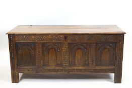 A carved elm chest with plain plank rectangular top,