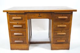 An oak twin pedestal desk with a plain rectangular top over a central drawer,