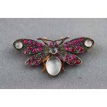 A yellow metal butterfly brooch set with cabochon moonstones and rubies. Pin and clip fitting.