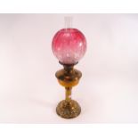 A Victorian oil lamp with etched cranberry tinted shade, on brass stand, 62.