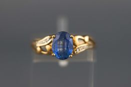 A yellow metal dress ring set with an oval sapphire