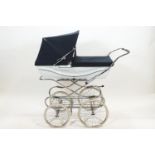 A mid 20th century Silver Cross pram, finished in white with navy blue hood,