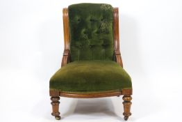 An Edwardian mahogany button back armchair with carved curved side rails above an over stuffed seat