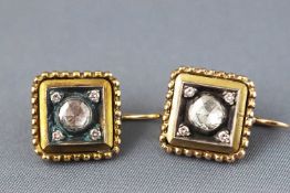 A yellow metal pair of earrings each set with a central rose cut diamond