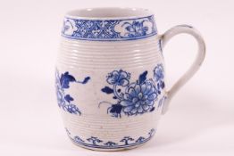 An 18th century English blue and white decorated barrel form mug with turned bands and sprigs of