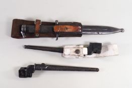 A bayonet in a steel scabbard on a leather belt fitment and two others