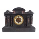 A slate and serpentine Temple clock with four engaged doric columns centred with an ivorine dial