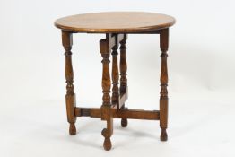 A small oak round folding table raised on a bobbin turned gate leg mechanics. 52cm high x 50cm wide.