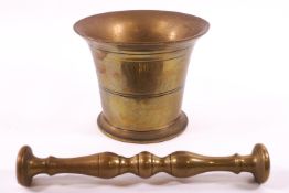 A late 18th century brass cast bell shaped and turned pestle and mortar,