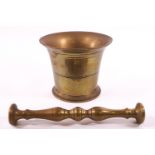 A late 18th century brass cast bell shaped and turned pestle and mortar,