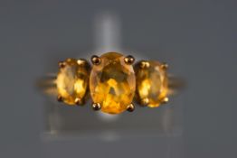 A yellow metal dress ring. Set with oval faceted cut citrines. Hallmarked 9ct gold, Birmingham.