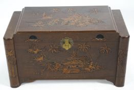A Camphor wood chest of traditional form and carved with Asian scenes, set an inner tray,
