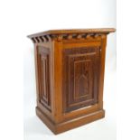 A pine lectern of traditional form with sloping rectangular top over panelled sides set with panels
