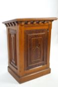 A pine lectern of traditional form with sloping rectangular top over panelled sides set with panels