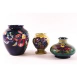 Three Moorcoft vases, the largest decorated with iris on a blue green ground,