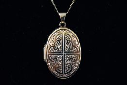 A yellow metal oval picture locket with embossed design suspended form a fine link curb chain.