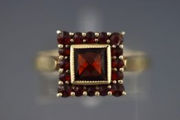 A yellow metal square cluster ring set with almandine garnets.