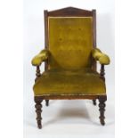 An Edwardian mahogany button back armchair with carved pediment style cresting,