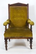 An Edwardian mahogany button back armchair with carved pediment style cresting,