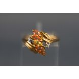 A yellow metal ring set with five marquise cut orange and yellow sapphires and finished with two....