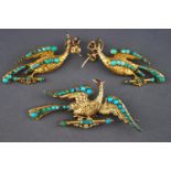 A yellow metal demi parure of brooch and earrings, designed as peacocks...