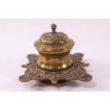 A 19th century brass ink well with domed cover over a waisted cylinder on a quatrefoil base,