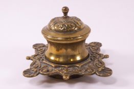 A 19th century brass ink well with domed cover over a waisted cylinder on a quatrefoil base,