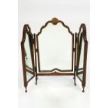 A carved wood Queen Anne style triptych dressing mirror with central shell cresting raised on