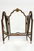 A carved wood Queen Anne style triptych dressing mirror with central shell cresting raised on