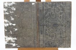 A pair of embossed panels laid onto wood and painted black,