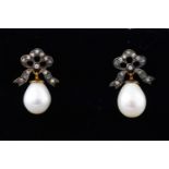 A yellow and white metal pair of drop earrings each having a freshwater pearl