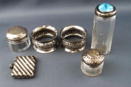 A pair of napkin rings with flared edges and bellied centres decorated with scrolling foliates,