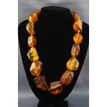 A single strand of large abstract amber beads with base metal hook clasp.