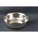 A porringer of traditional round form, with a pierced strap handle and a band of engraved swag,