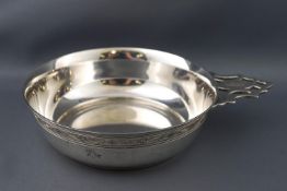 A porringer of traditional round form, with a pierced strap handle and a band of engraved swag,