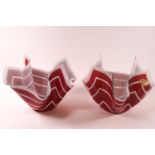 Two glass handkerchief bowls, decorated with white stripes on red ground.