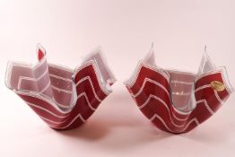 Two glass handkerchief bowls, decorated with white stripes on red ground.