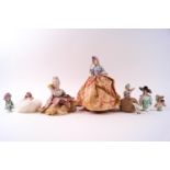 A group of seven porcelain half doll pin cushion ladies,