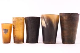 A collection of five horn beakers, the largest 12cm high,