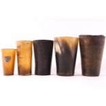 A collection of five horn beakers, the largest 12cm high,