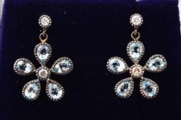 A yellow and white metal pair of flower drop earrings