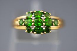A yellow metal dress ring set with intense green peridot (untested) and single cut diamonds.