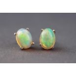 A white metal single stone pair of stud earrings, each set with cabochon Ethiopian opals.