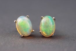 A white metal single stone pair of stud earrings, each set with cabochon Ethiopian opals.