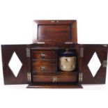 An oak smoker's cabinet with two lozenge glazed doors and lifting top,