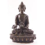 A bronze figure of the seated Buddha, seen in the lotus position,