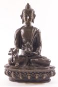 A bronze figure of the seated Buddha, seen in the lotus position,