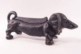 A black painted iron boot scraper, modelled as a dachshund,