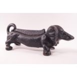 A black painted iron boot scraper, modelled as a dachshund,